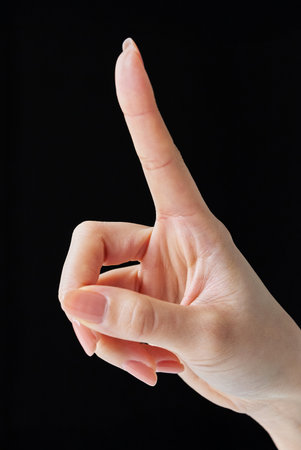 Touching gesture with index finger and black backgroundの写真素材