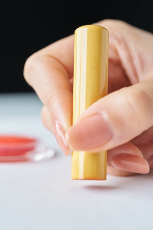 close up of hands stamping a white piece of paperの写真素材