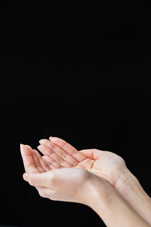 Scooping up with the palm of your hand and black backgroundの写真素材