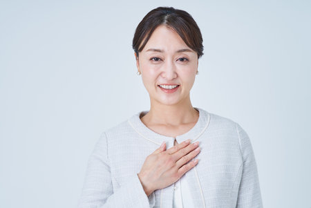 Business woman with hand on chest and white backgroundの写真素材