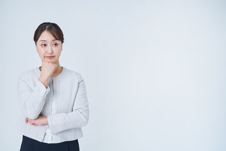 Business woman in a worried pose and white backgroundの写真素材