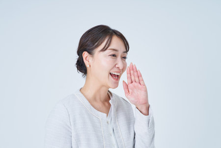 Business woman posing to cheer and white backgroundの写真素材