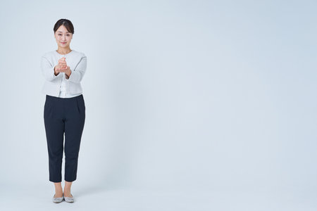 Business woman nodding with both hands and white backgroundの写真素材
