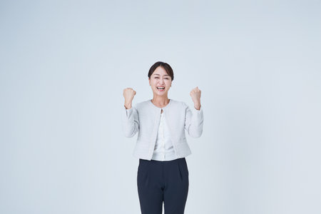 Business woman posing to cheer and white backgroundの写真素材