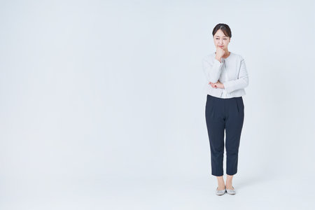 Business woman in a worried pose and white backgroundの写真素材