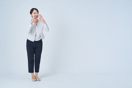Business woman posing to cheer and white backgroundの写真素材