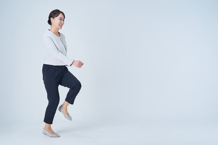 Asian business woman is walking and white backgroundの写真素材