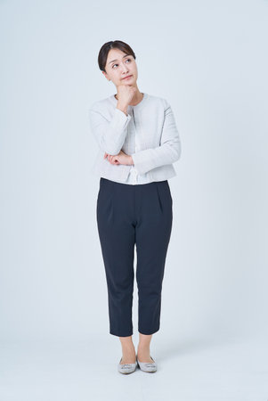 Business woman in a worried pose and white backgroundの写真素材