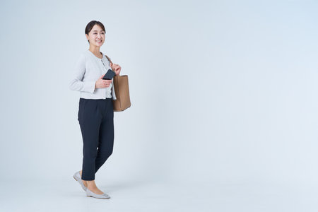 Asian business woman is walking and white backgroundの写真素材