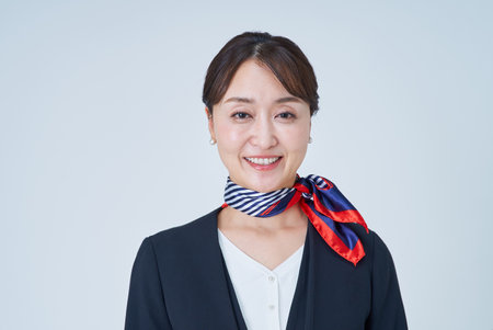 A woman in a suit with a scarf around her neck and white backgroundの写真素材