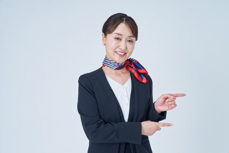 A woman in a suit posing with a finger and white backgroundの写真素材