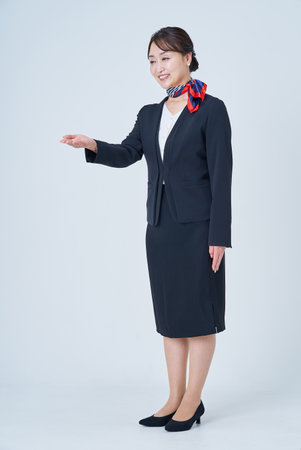 A woman in a suit posing for guidance and white backgroundの写真素材