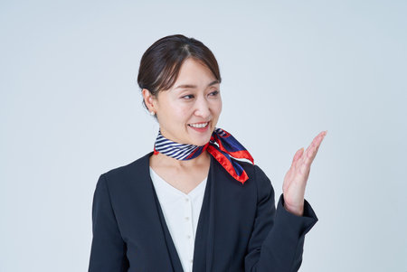 A woman in a suit posing for guidance and white backgroundの写真素材
