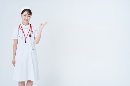A female medical staff member posing as a guide and white backgroundの写真素材