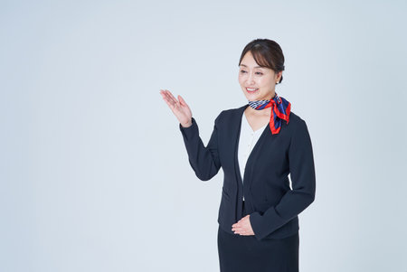 A woman in a suit posing for guidance and white backgroundの写真素材