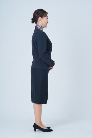 A woman in a suit with a scarf around her neck and white backgroundの写真素材