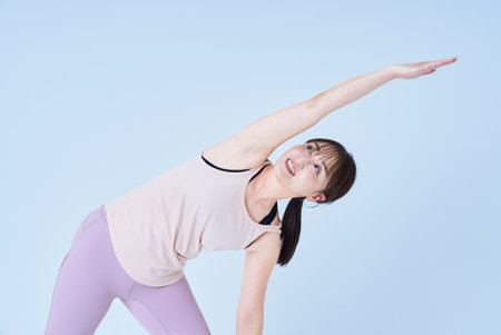 Asian woman doing yoga pose and white backgroundの写真素材