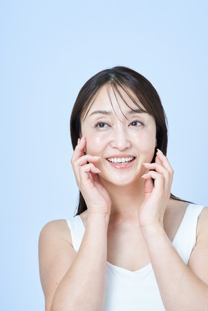 Middle aged woman touching her skin and white background