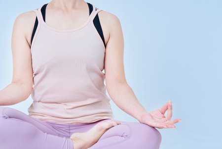 Woman meditating in yoga pose and white backgroundの写真素材