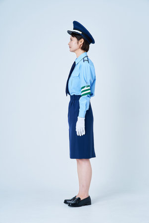 A woman in a security guard or police uniform and white backgroundの写真素材