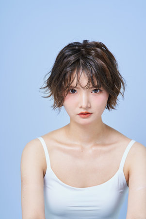 Portrait of a young woman against a white backgroundの写真素材
