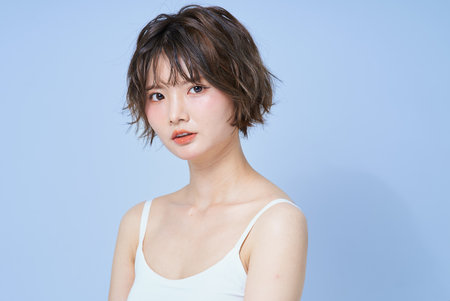 Portrait of a young woman and white backgroundの写真素材