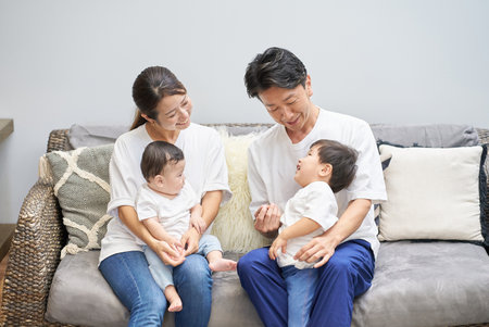 Parents and children relaxing on the sofa in a roomの写真素材
