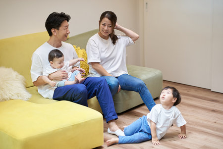 Parents and children relaxing on the sofa in a roomの写真素材