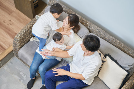 Parents and children relaxing on the sofa in a roomの写真素材