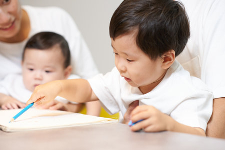 Boy and family drawing in the living roomの写真素材