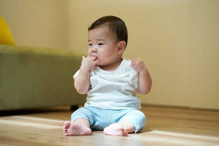Cute infant playing alone in a room
