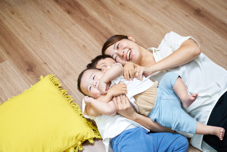 Mother and children playing happily in the roomの写真素材