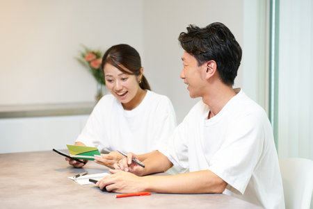A man and a woman looking at their bank account passbookの写真素材