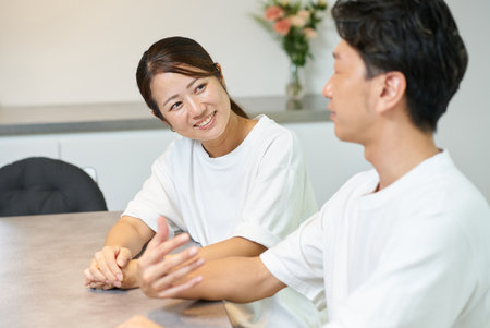 A woman looking at a man with a gentle expression indoorsの写真素材