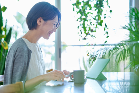 Middle-aged woman working in the living roomの写真素材