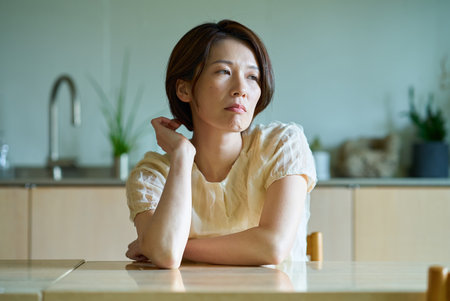 Middle-aged woman feeling tired in her roomの写真素材