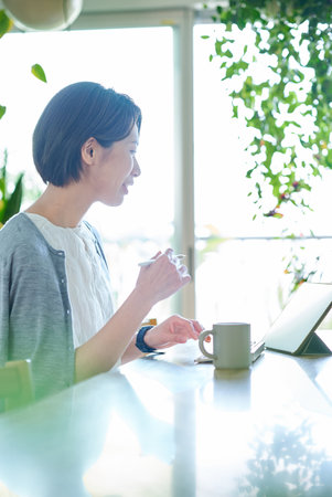 Middle-aged woman working in the living roomの写真素材