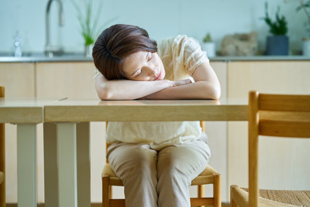 A middle-aged woman resting in a roomの写真素材