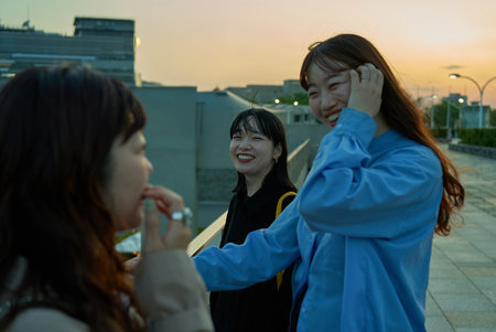 Three young women chatting happily at sunset
