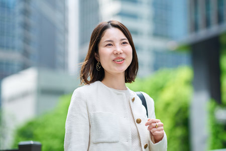 A smiling woman commuting in a business districtの写真素材