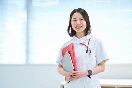 Portrait of a young woman in a white coatの写真素材