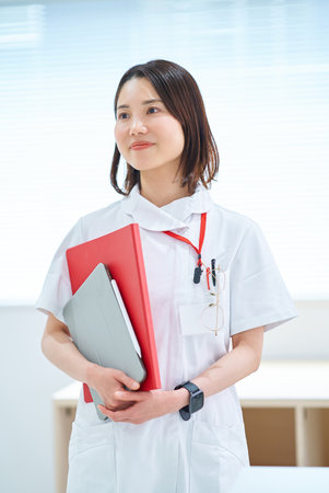 Portrait of a young woman in a white coatの写真素材