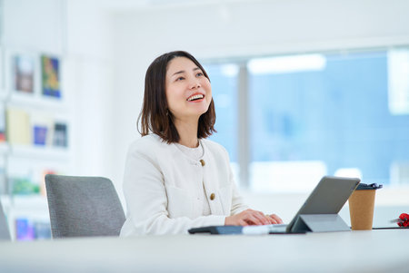 A young woman talking to a colleague at workの写真素材