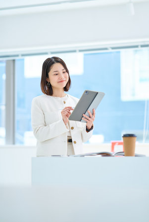 A young woman operating a tablet PCの写真素材