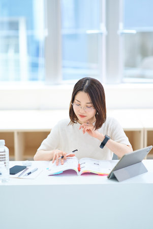 A young woman studying with textbookの写真素材