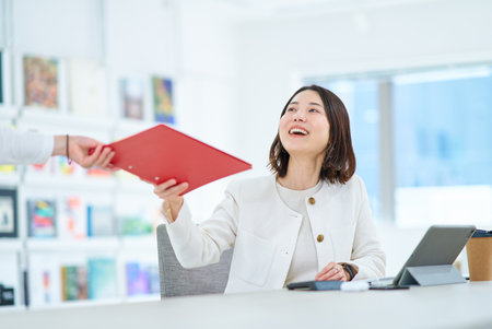 A young woman working in a friendly atmosphereの写真素材
