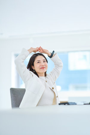 A young woman taking a deep breath indoorsの写真素材