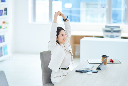 A young woman taking a deep breath indoorsの写真素材