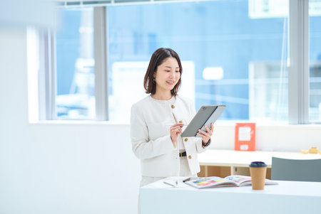 A young woman operating a tablet PCの写真素材