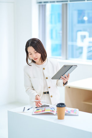 A young woman operating a tablet PCの写真素材